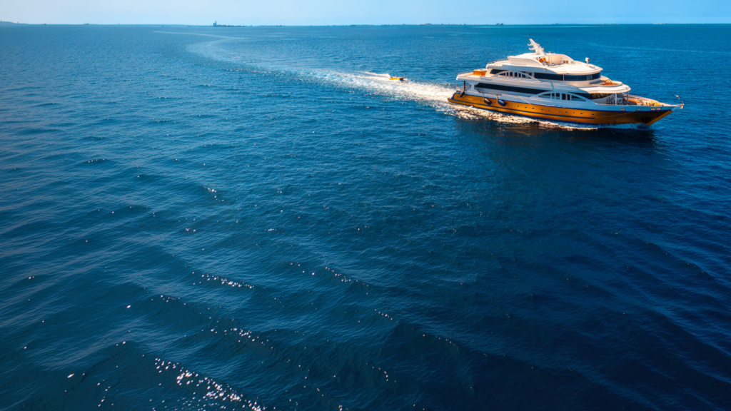 Aerial view of a Legend & Beyond liveaboard vessel cruising across deep blue water